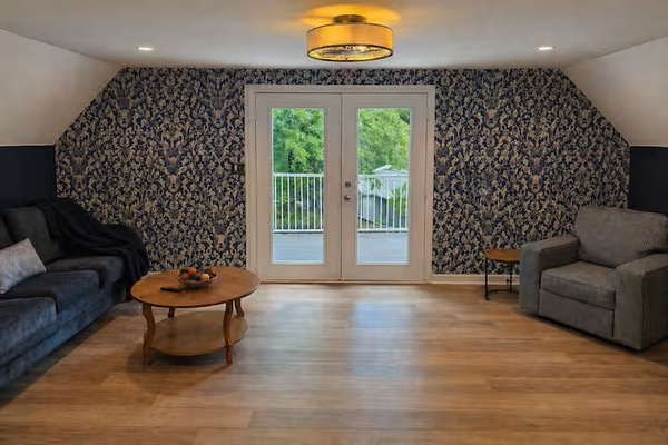 Comfortable second-floor loft with lounge seating, natural light and easy access to the upper deck with lake views.