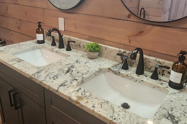 Spacious double vanity with granite countertop and modern fixtures.