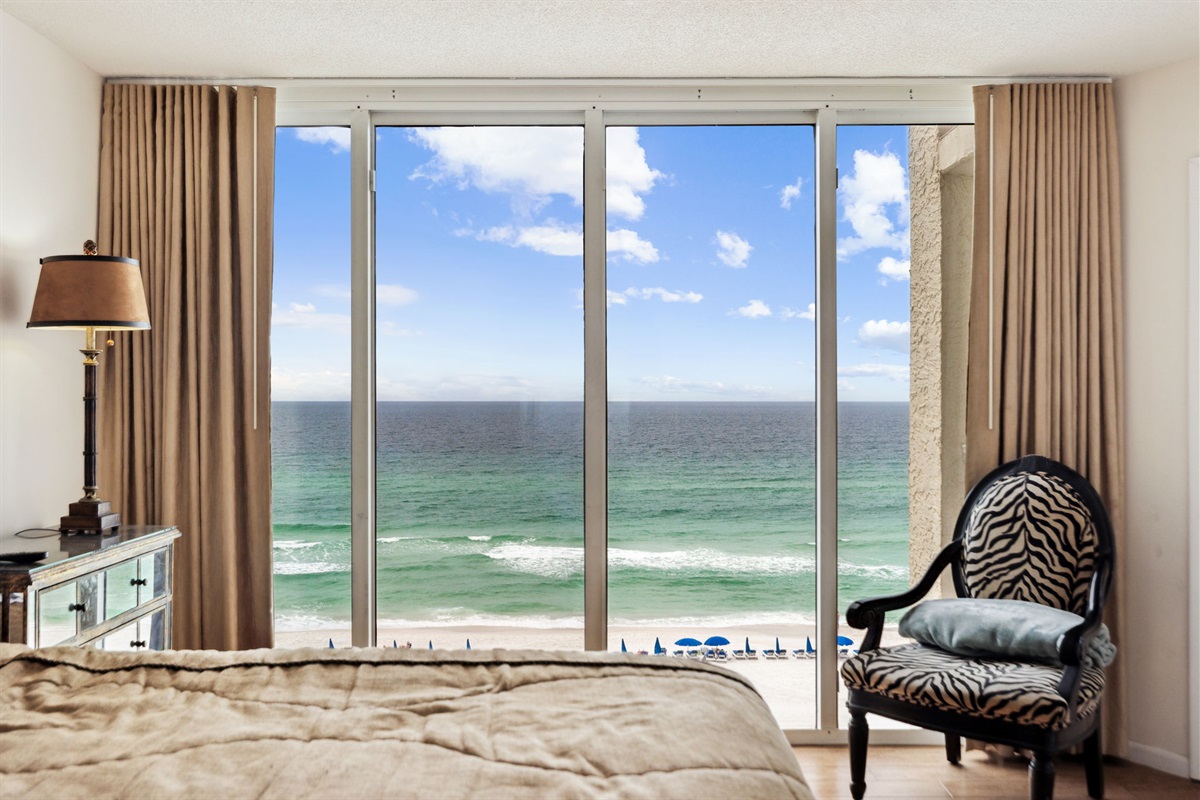 Master king suite bedroom with floor to ceiling windows showcasing the beautiful Emerald Gulf waters, balcony access from bedroom and en suite bathroom