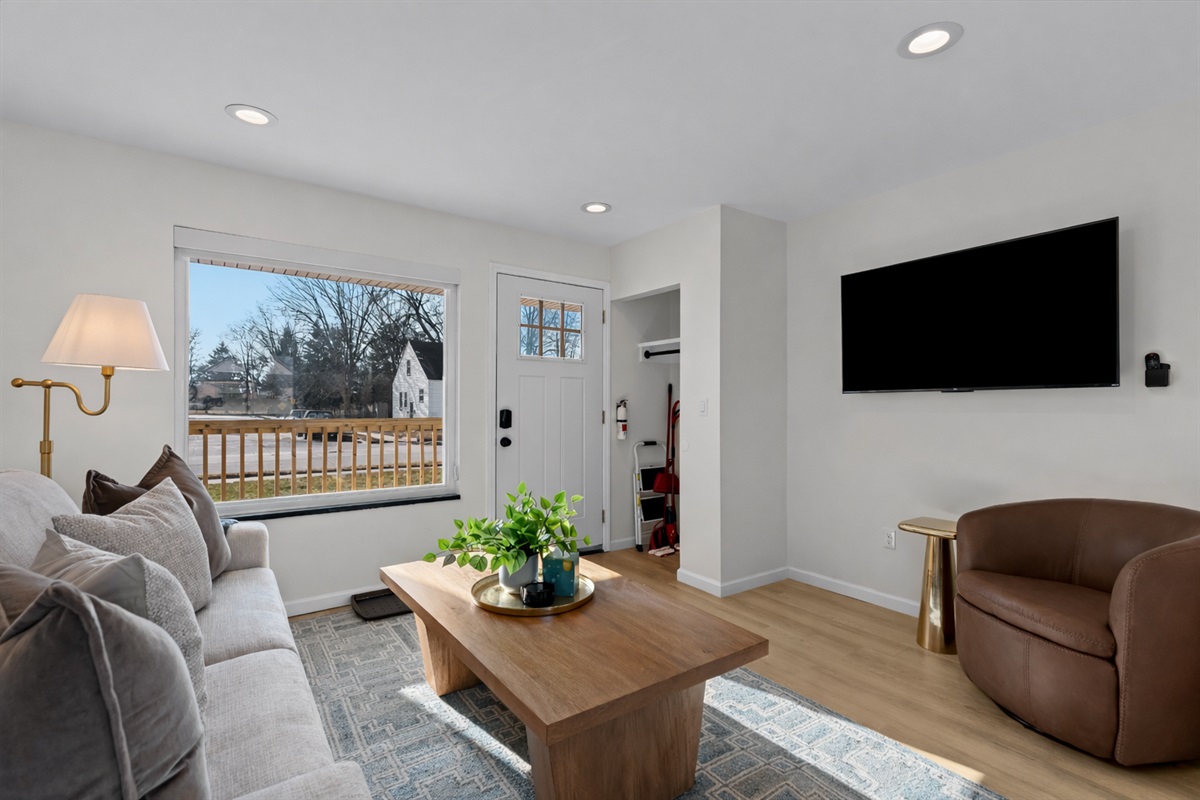Sun-filled living room with plush seating, smart TV, and a large window—perfect for relaxing, streaming your favorites, or enjoying the natural light.