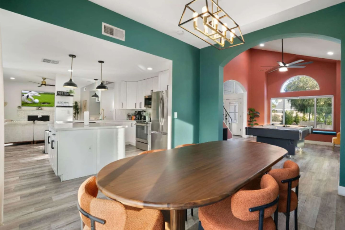 Expansive open layout with colorful accent walls, chef's kitchen, game room, and multiple living zones.