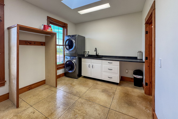 Laundry room with washer, dryer, and utility sink.