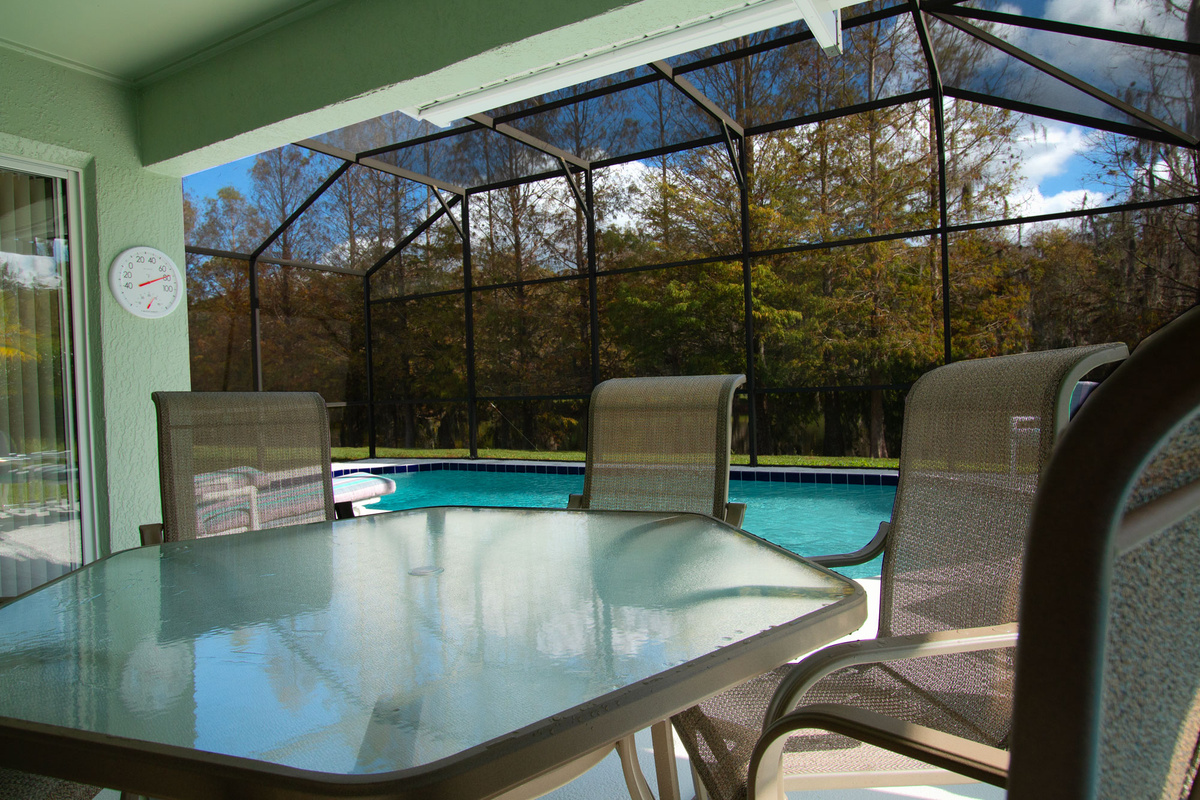 Covered lanai by the Private Screened Pool with outdoor dining area.