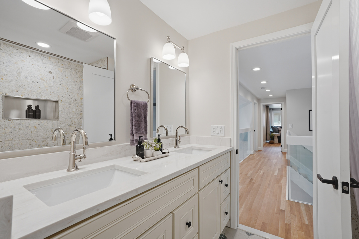 This spacious double-vanity bathroom features modern finishes, ample counter space, and a bright, clean design perfect for groups and families.