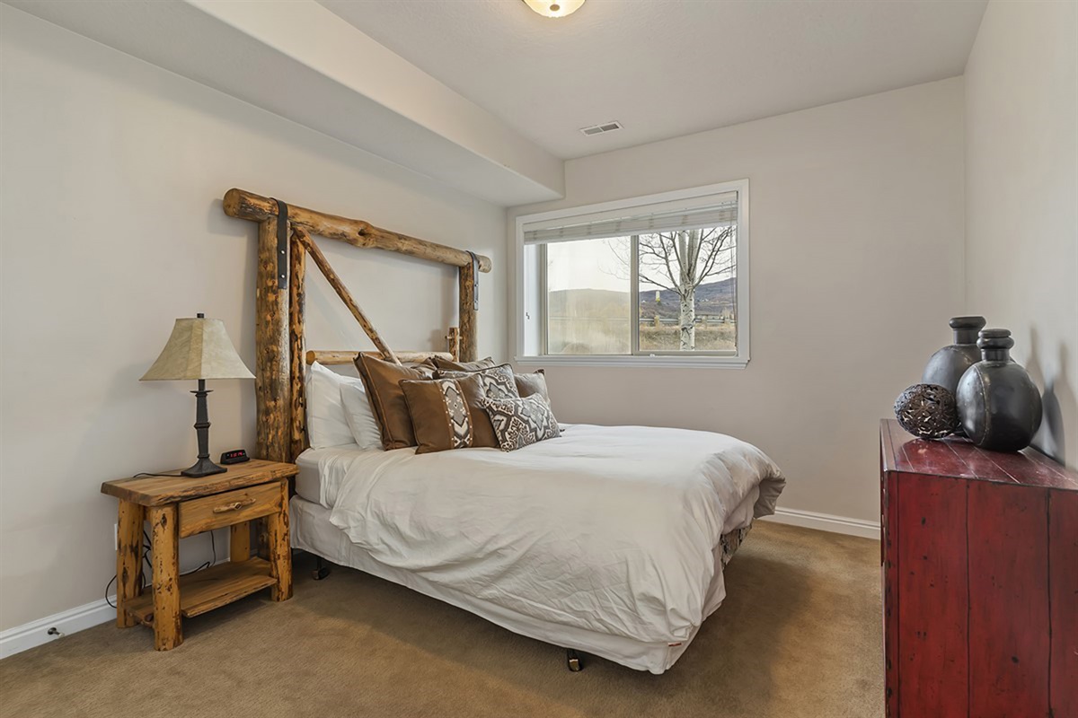 A charming lower-level bedroom with warm wood accents and inviting décor, ideal for restful nights.