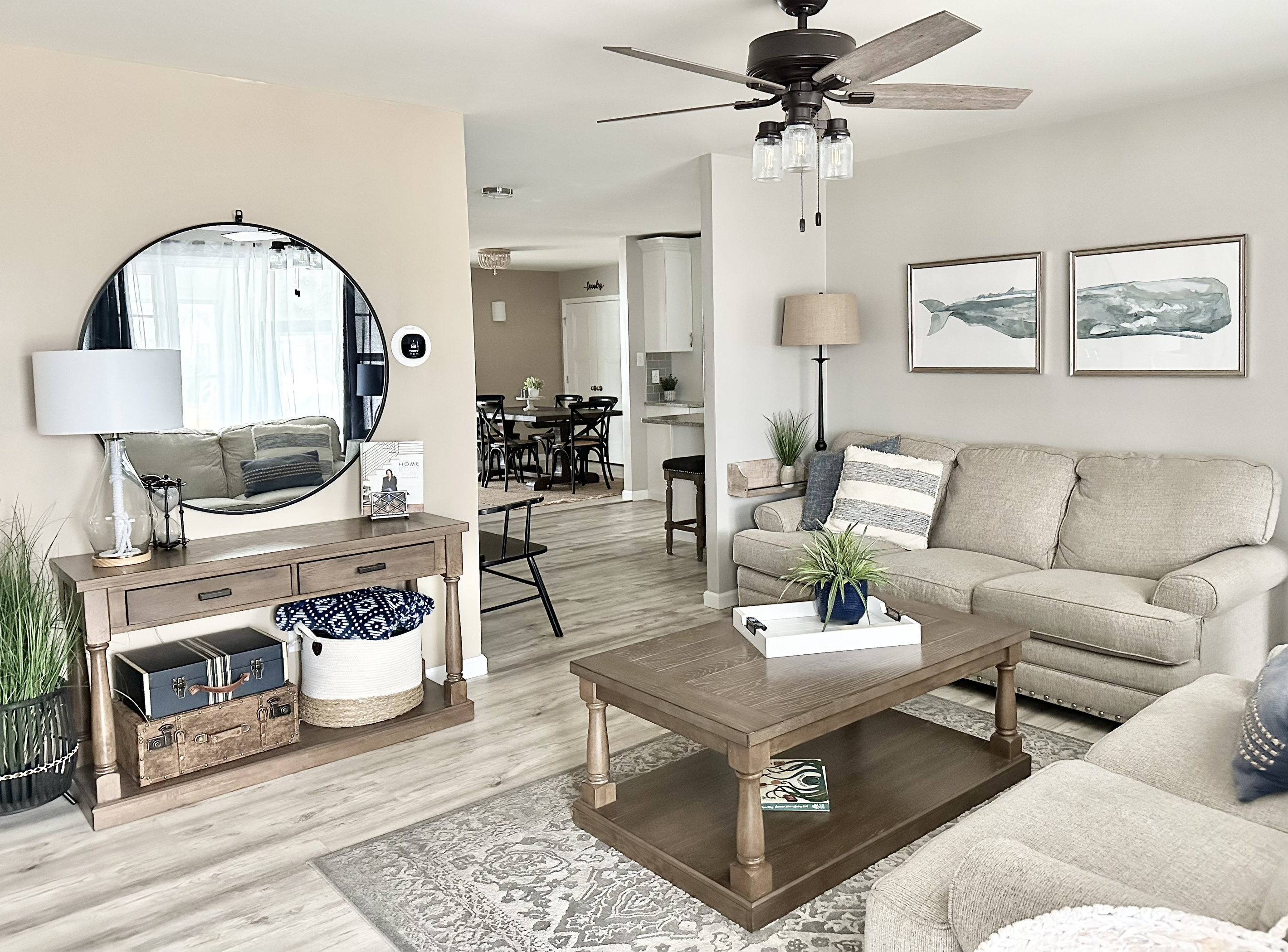 Relax in our modern farmhouse living room featuring a plush sectional, rustic wood accents, and coastal decor. This open-concept space flows into the dining area, perfect for movie nights or morning coffee in a bright, airy atmosphere.