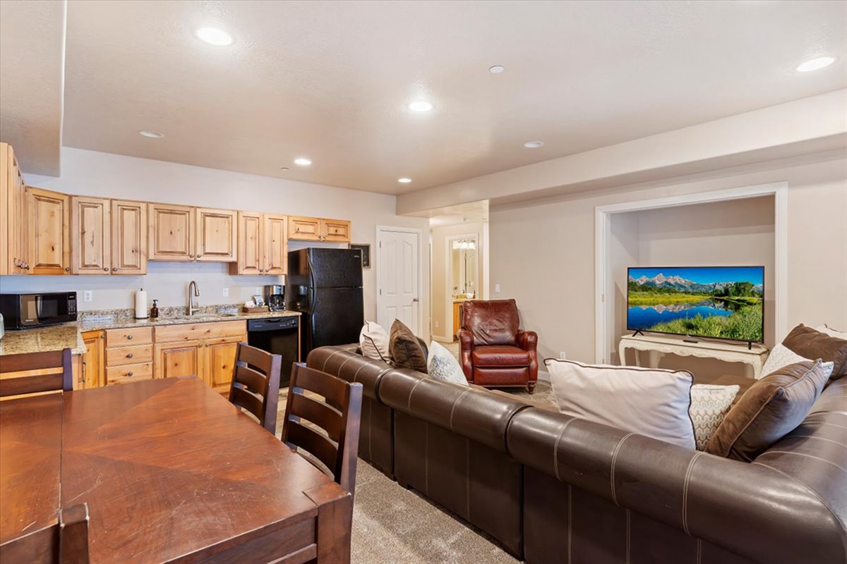 A spacious downstairs entertainment area with open seating and kitchen access (no oven), ideal for hosting, relaxing, and enjoying time together.