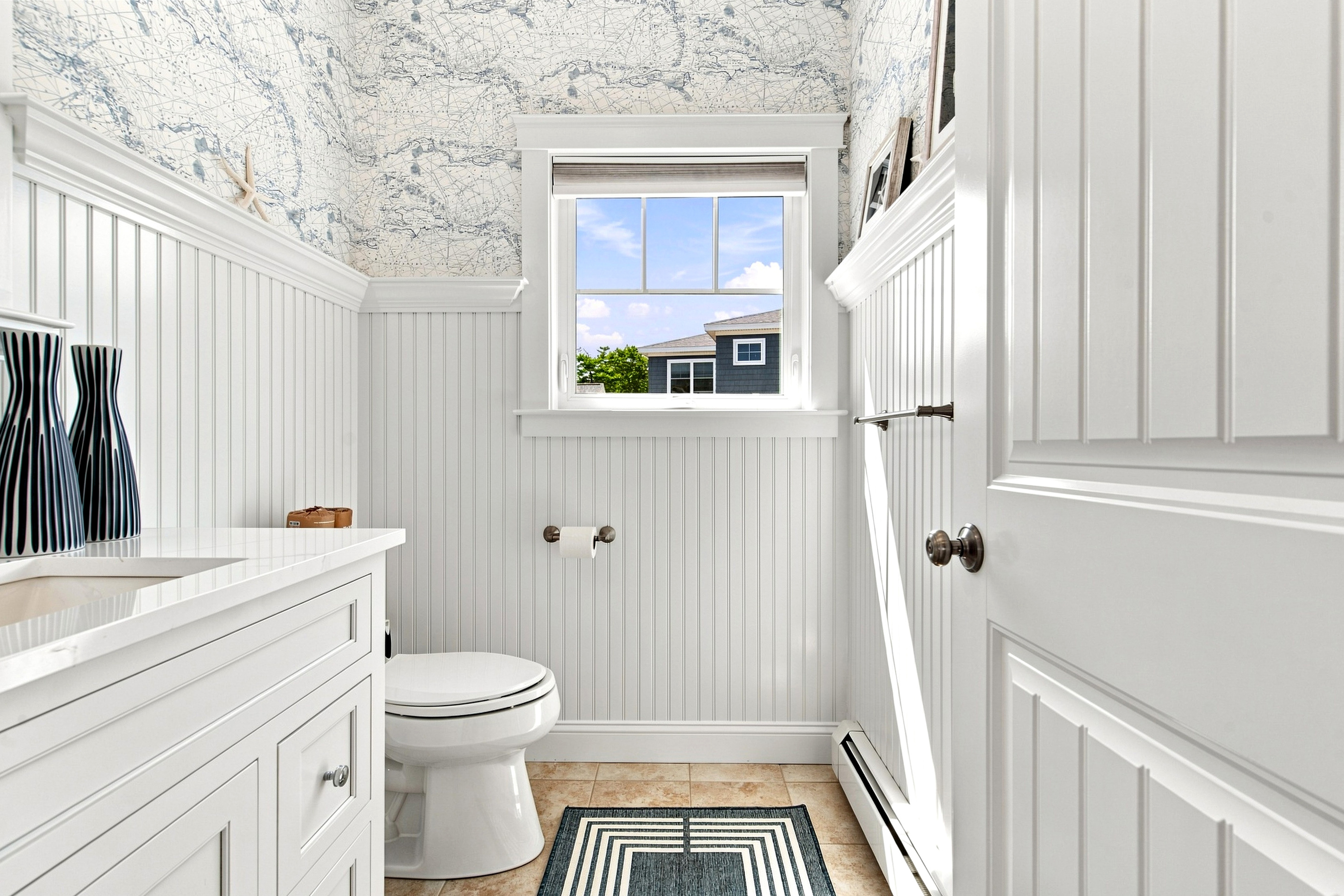 A fresh, coastal-inspired bathroom provides a bright and convenient space to refresh after a day by the ocean.