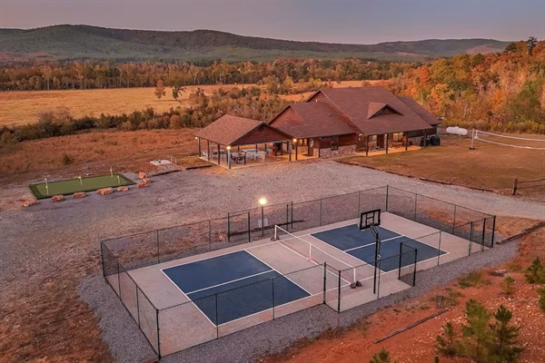 Twilight aerial showing the full recreation area and cabin illuminated at dusk.