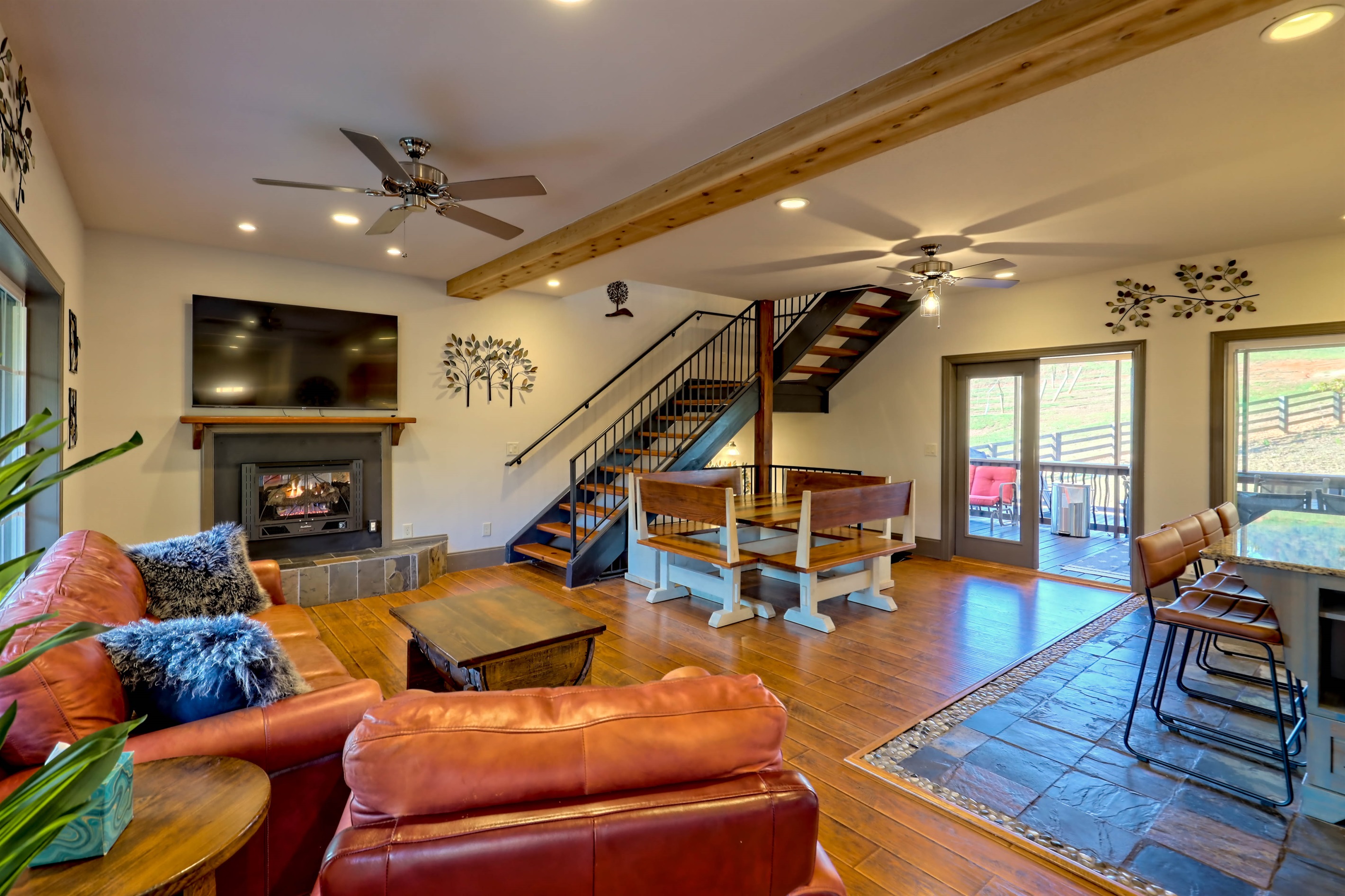 Open-concept living area featuring plush seating, a fireplace, and vineyard views—great for relaxing after a day in Helen.