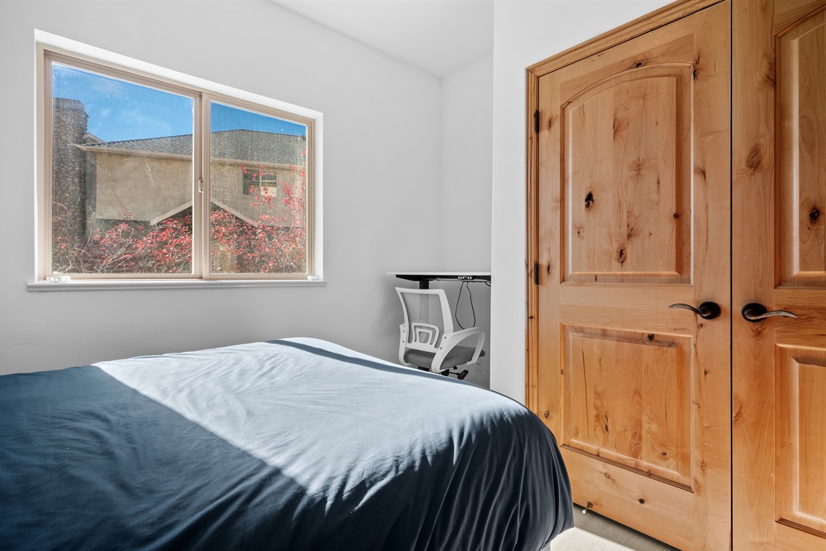 The fourth bedroom is outfitted with a queen bed, luxurious linens, and plush pillows.