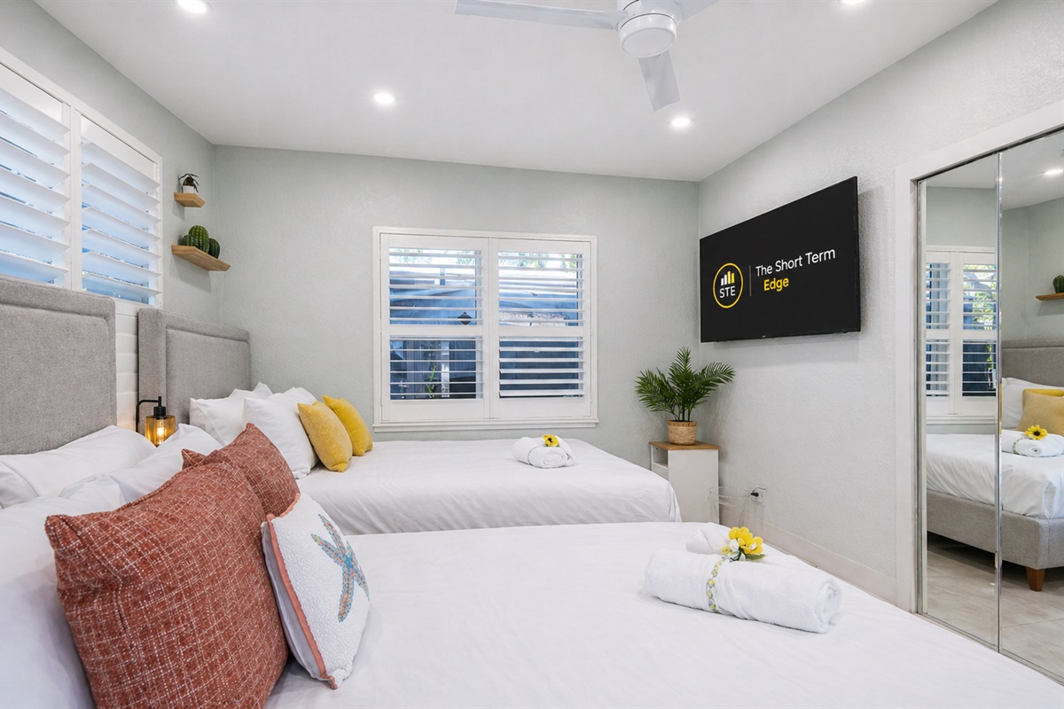 Two queen beds and straight out to the backyard — comfort meets fresh air 🌿- equipped w/ a Smart TV