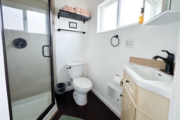 Crisp white bathroom w/ walk-in shower & bright finishes