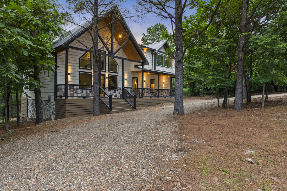Welcome to Hit Refresh, tucked peacefully among the pines and ready for your next getaway. 
Glowing windows, cozy covered decks, and a quiet forest setting, this cabin instantly feels like the kind of place where life slows down and good memories begin.