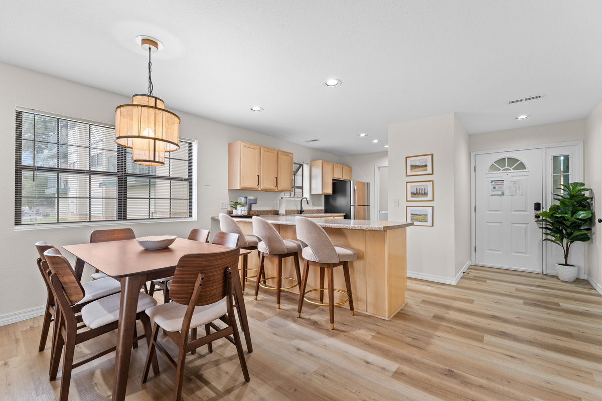 The dining table seats six, with the kitchen and breakfast bar close at hand.