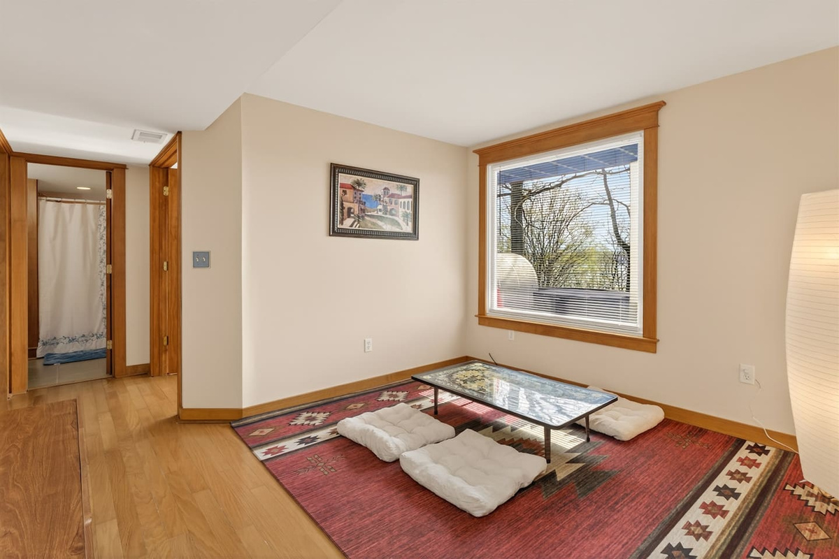 Relax in a Japanese-style living room with a low table, floor seating cushions, and warm, calming design—perfect for tea, conversation, or quiet moments, blending comfort and culture into a unique, peaceful retreat experience