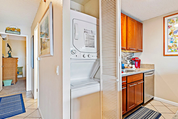 Stacked washer/dryer in unit.