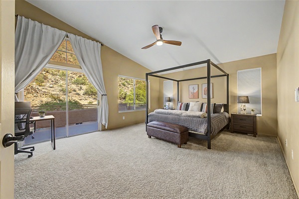Primary suite with king bed, 55” smart tv, blackout blinds, ceiling fan, remote workstation, walk in closet, ensuite bathroom and private deck