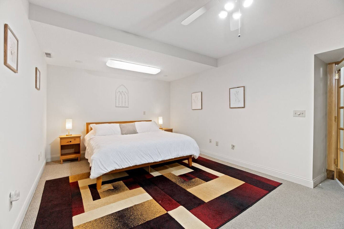Luxurious king-sized bed with a large carpet beneath, adding comfort and warmth to the spacious bedroom for a relaxing stay.
