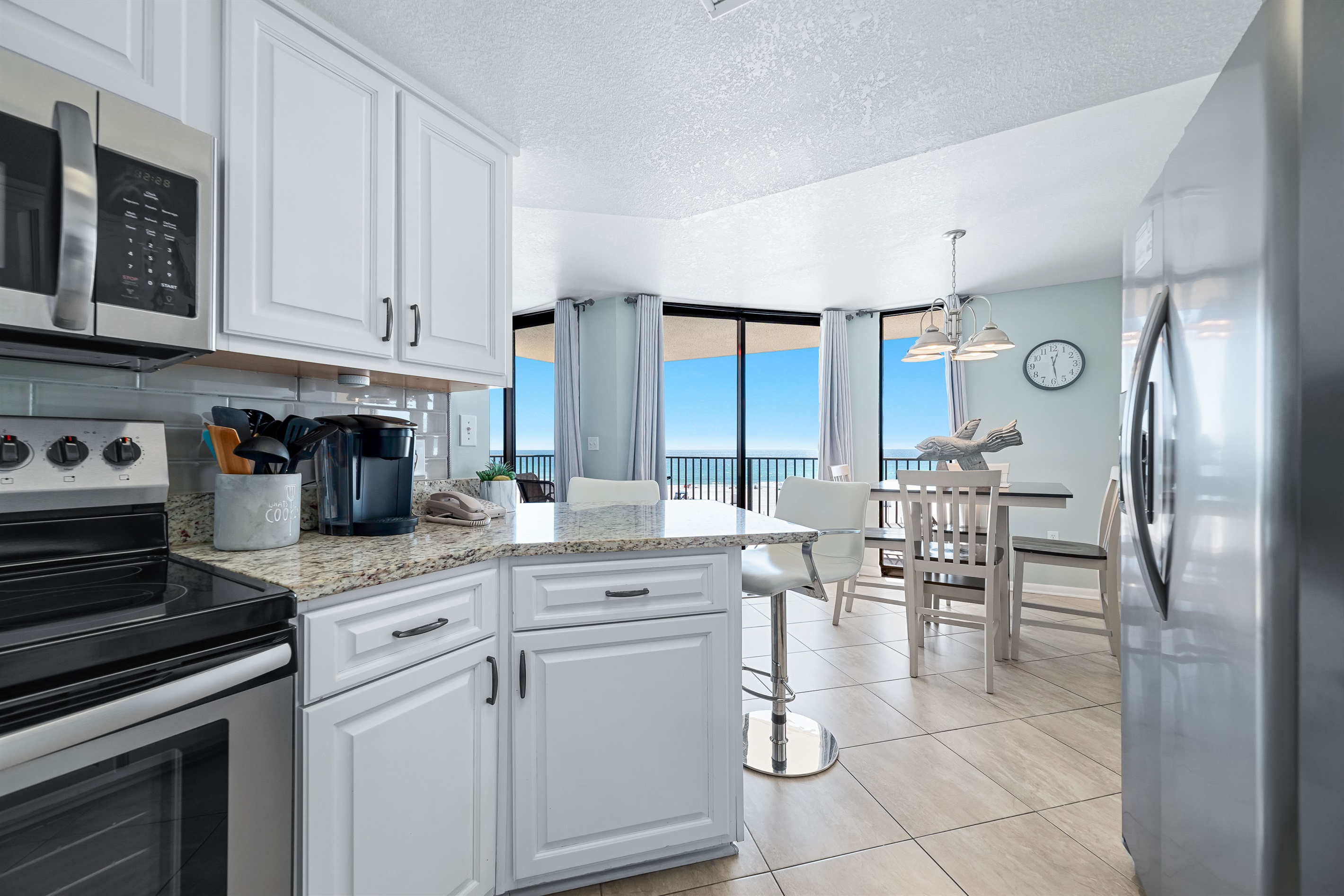 This beautifully updated kitchen features bright white cabinetry, granite countertops, and a crisp subway tile backsplash. Abundant natural light and those gorgeous ocean views make meal prep a joy.