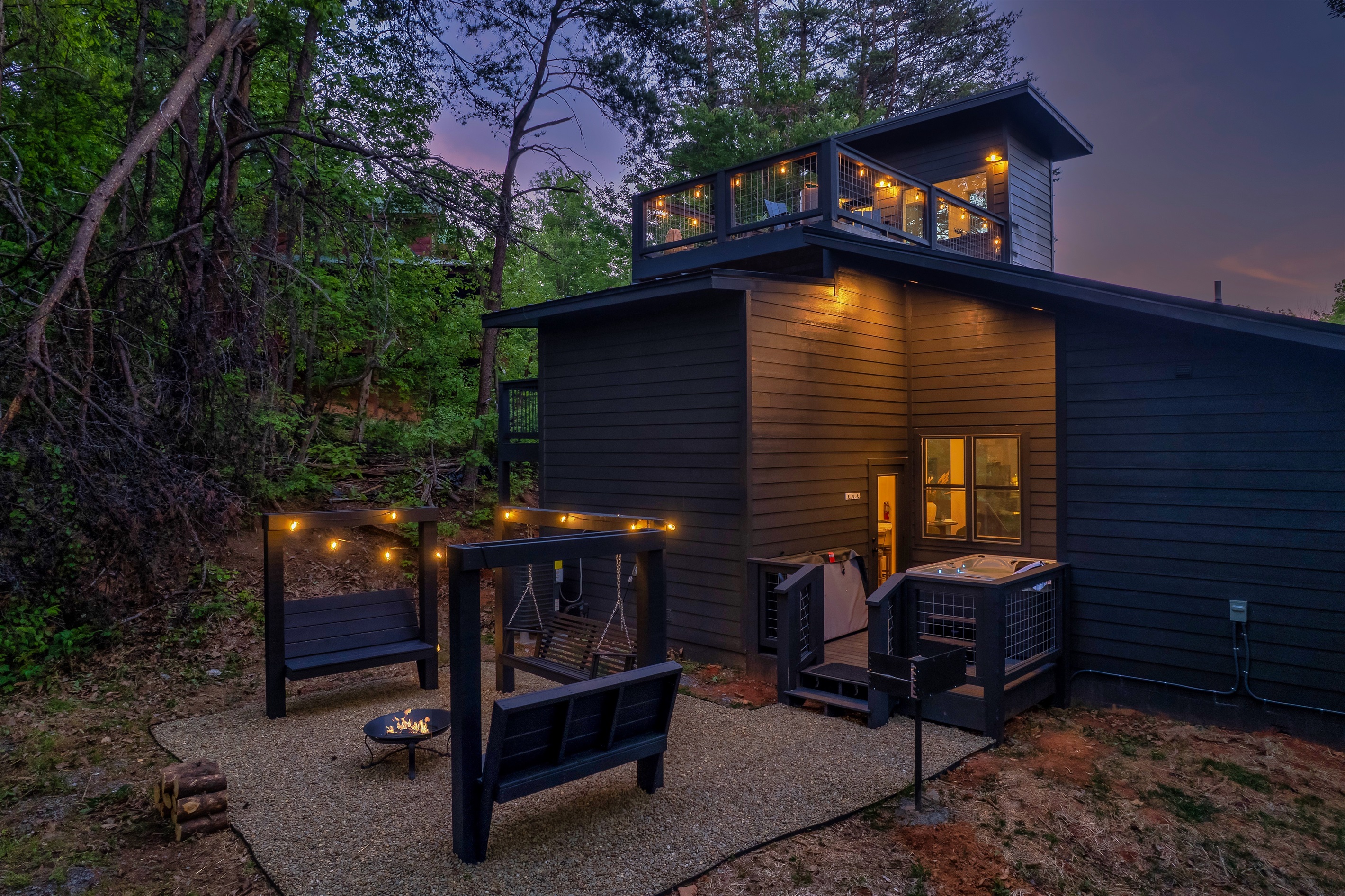Exterior of cabin with fire pit, hot tub and a couples swing
