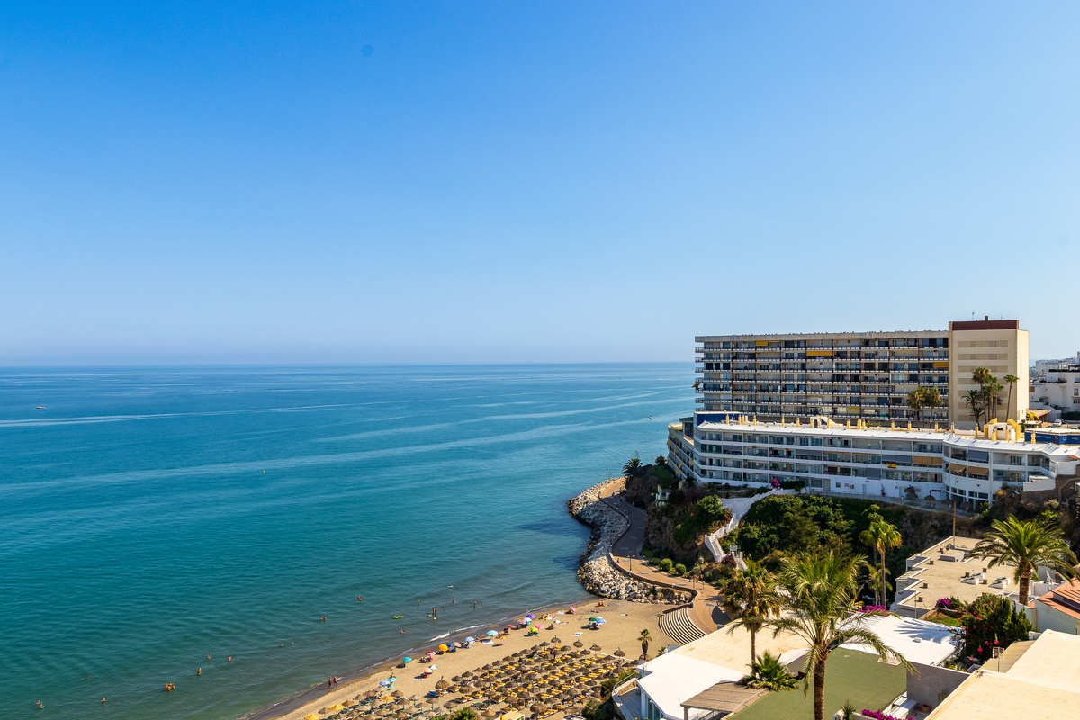 Elevated coastal panorama over the Mediterranean and beach below.