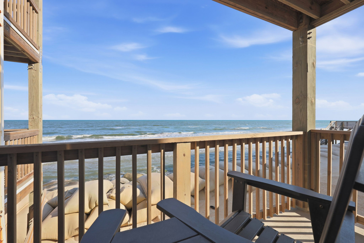 A comfortable outdoor seating area overlooking the beach, offering the ideal place to unwind and enjoy the coastal breeze
