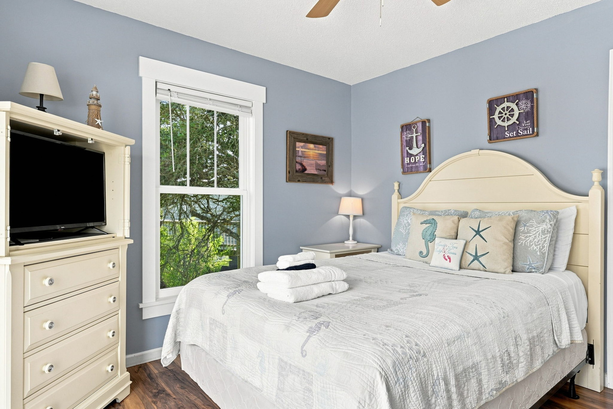 A bright and peaceful retreat with plush bedding, coastal d&eacute;cor, and plenty of natural light