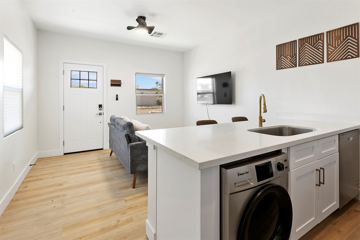 Bright and homey living room with ceiling fan. Combo washer/dryer