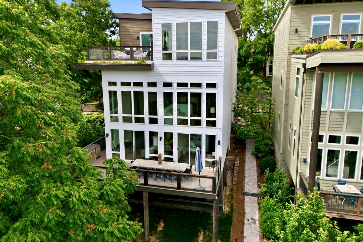 Treetop exterior shot showcasing the home's multi-level design surrounded by lush greenery.
