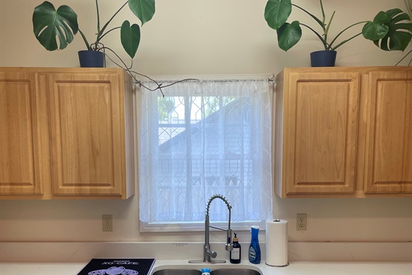 Updated kitchen featuring white quartz tops, stove/oven, full sized fridge, microwave,  and dish washer!