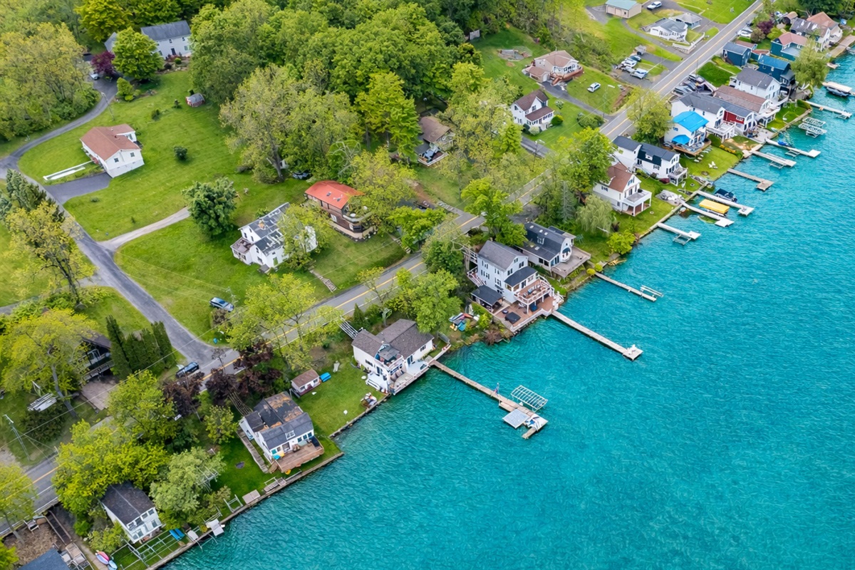 Aerial shot showcasing expansive lakefront entertaining space, hot tub, and private dock for the ultimate getaway 🎯🌊🍹