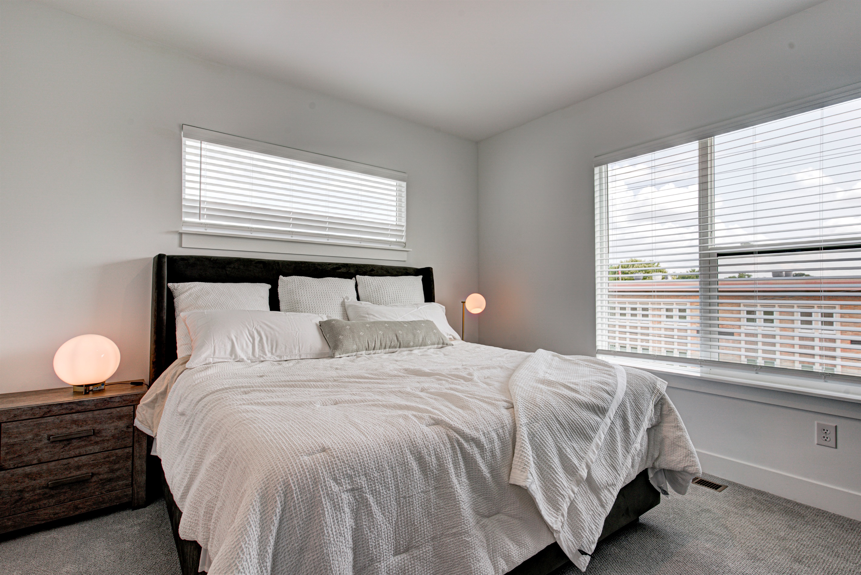 Relax in the serene master bedroom featuring a comfortable king-size bed, soft linens, and cozy pillows. Includes nightstands, lamps, walk-in closet, and full-length mirror for added comfort.