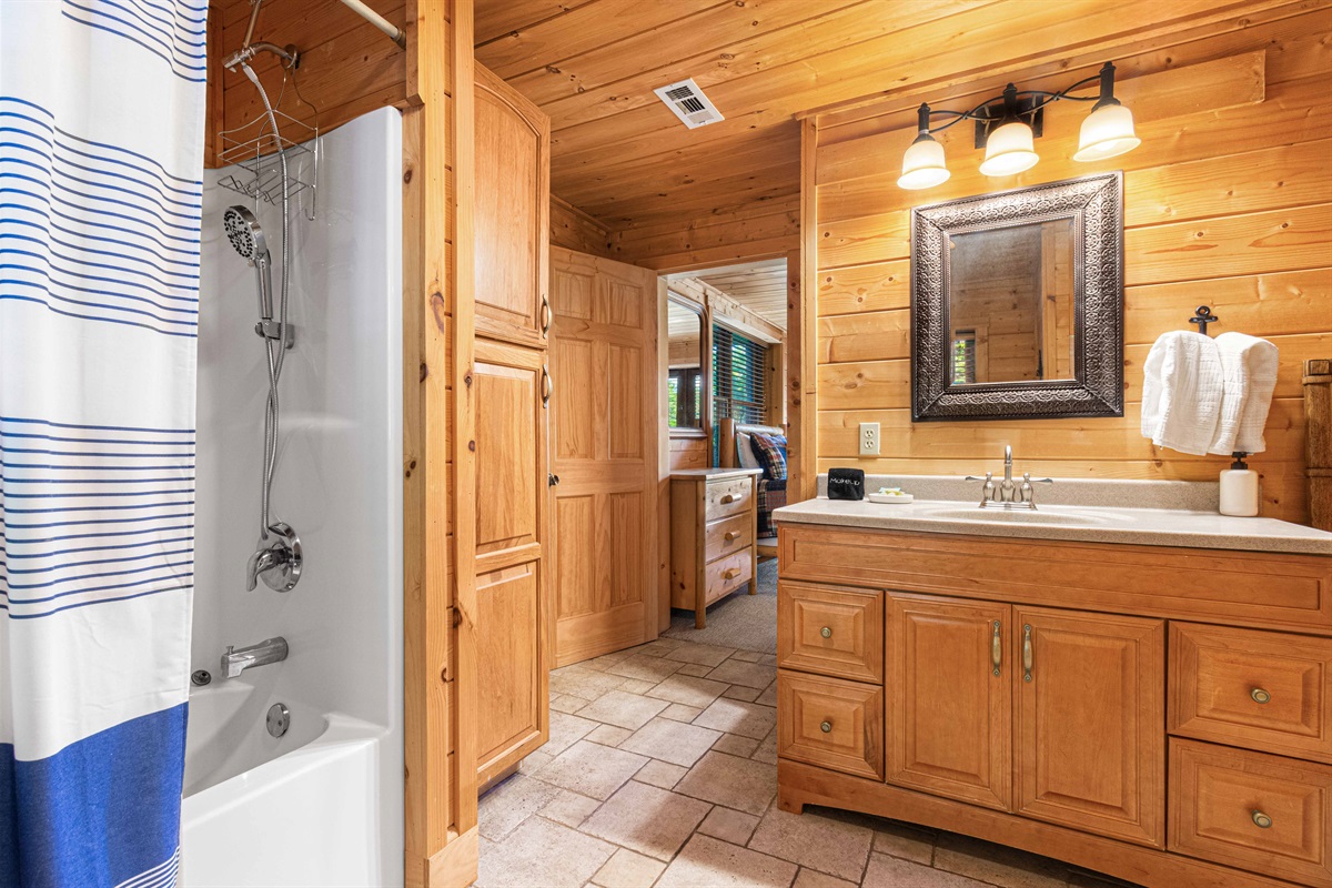 Downstairs Bathroom: Spacious elegance with wood details and a relaxing tub for a refreshing retreat!