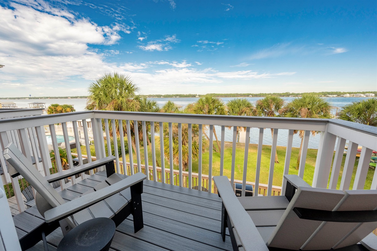 Tranquil waterfront balcony with palm trees and stunning views for ultimate relaxation.