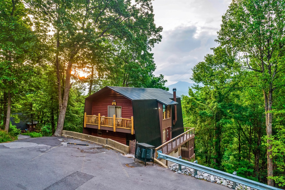 Front view of the cabin with parking spaces, and a security camera at the door entrance