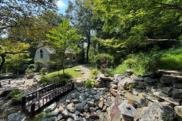 The Luxury Mountain Cottage and Suite nestled in the forest with view of bridge and waterfall.
