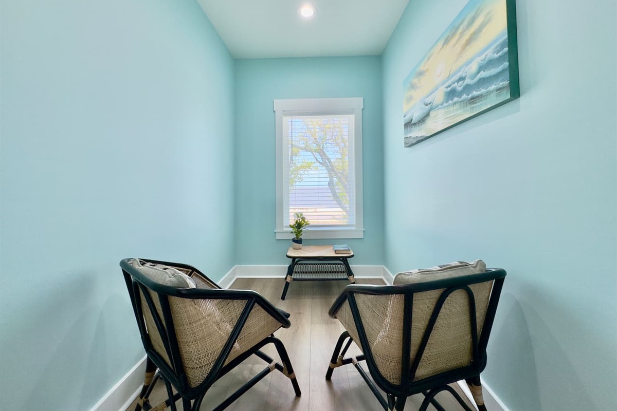 A cozy reading nook with chairs and a serene water view.