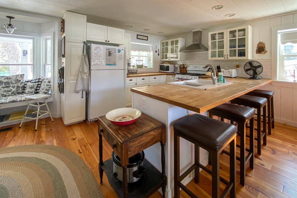 Full chef's kitchen with bar seating area. This is the breathing heart of the house, you turn around and there's the view over the lake.