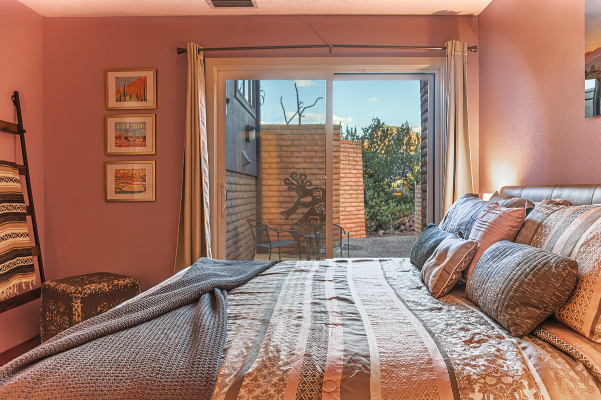 Private lower-level guest suite featuring a dedicated bathroom nearby and seamless access to the outdoor patio.
