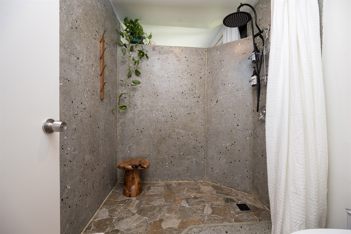 The concrete shower wall adds a touch of rustic charm to the modern bathroom.