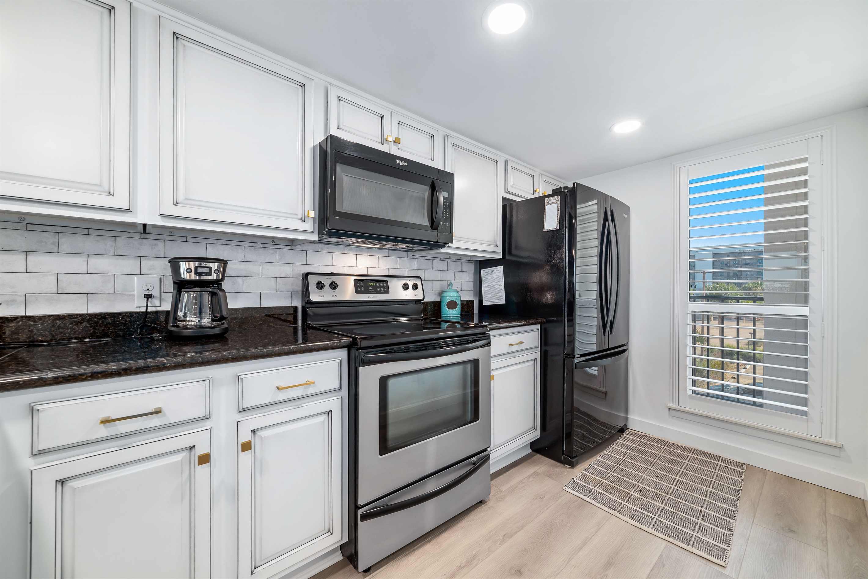 Updated kitchen with stainless steel appliances, quartz countertops, and a contemporary backsplash, offering both functionality and aesthetic appeal.