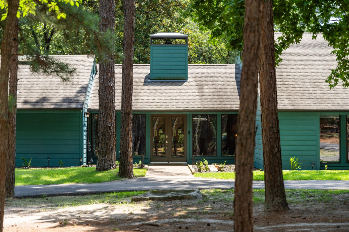 Welcome to Teal Paradise! The lush front yard features greenery, double doors, and step-free access, blending beauty and accessibility—setting a serene tone for the comfort inside.