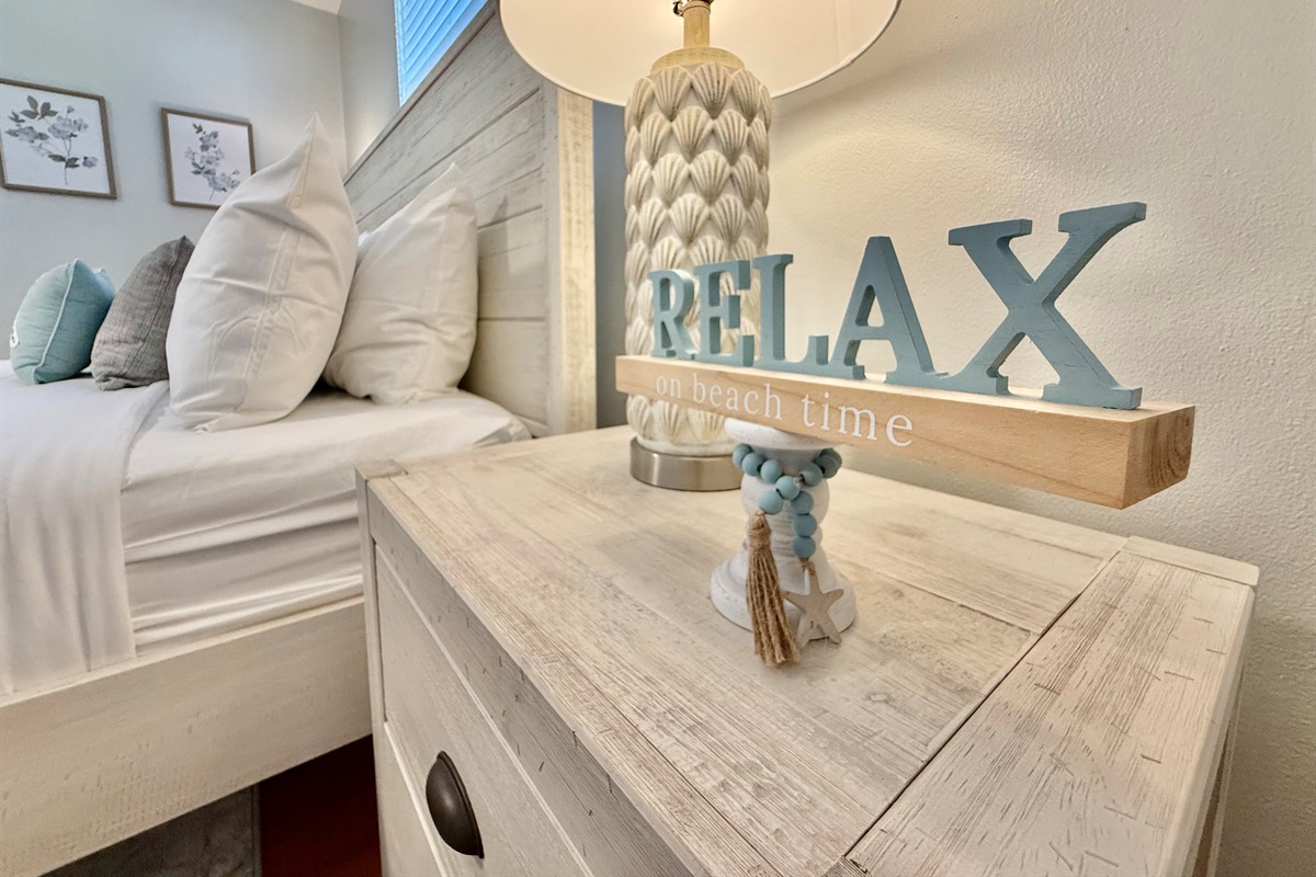 A tranquil haven featuring a stylish wood bed frame, fresh linens, and calming sea-inspired decor.