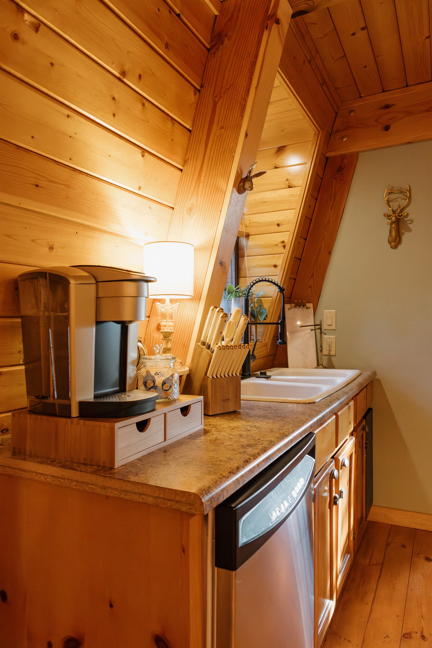 The compact kitchen at Poppywood Pines features granite countertops, Keurig coffee maker, and farmhouse sink beneath dramatic A-frame beams. This efficient Show Low cabin provides everything needed for your White Mountains vacation cooking and entertaining