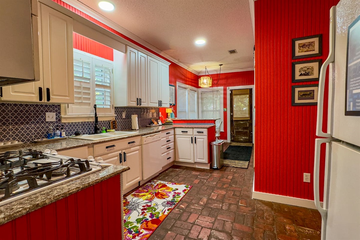 Vibrant kitchen with bold red accents, modern cabinetry, and full appliances—an energetic, stylish space for cooking and gathering.