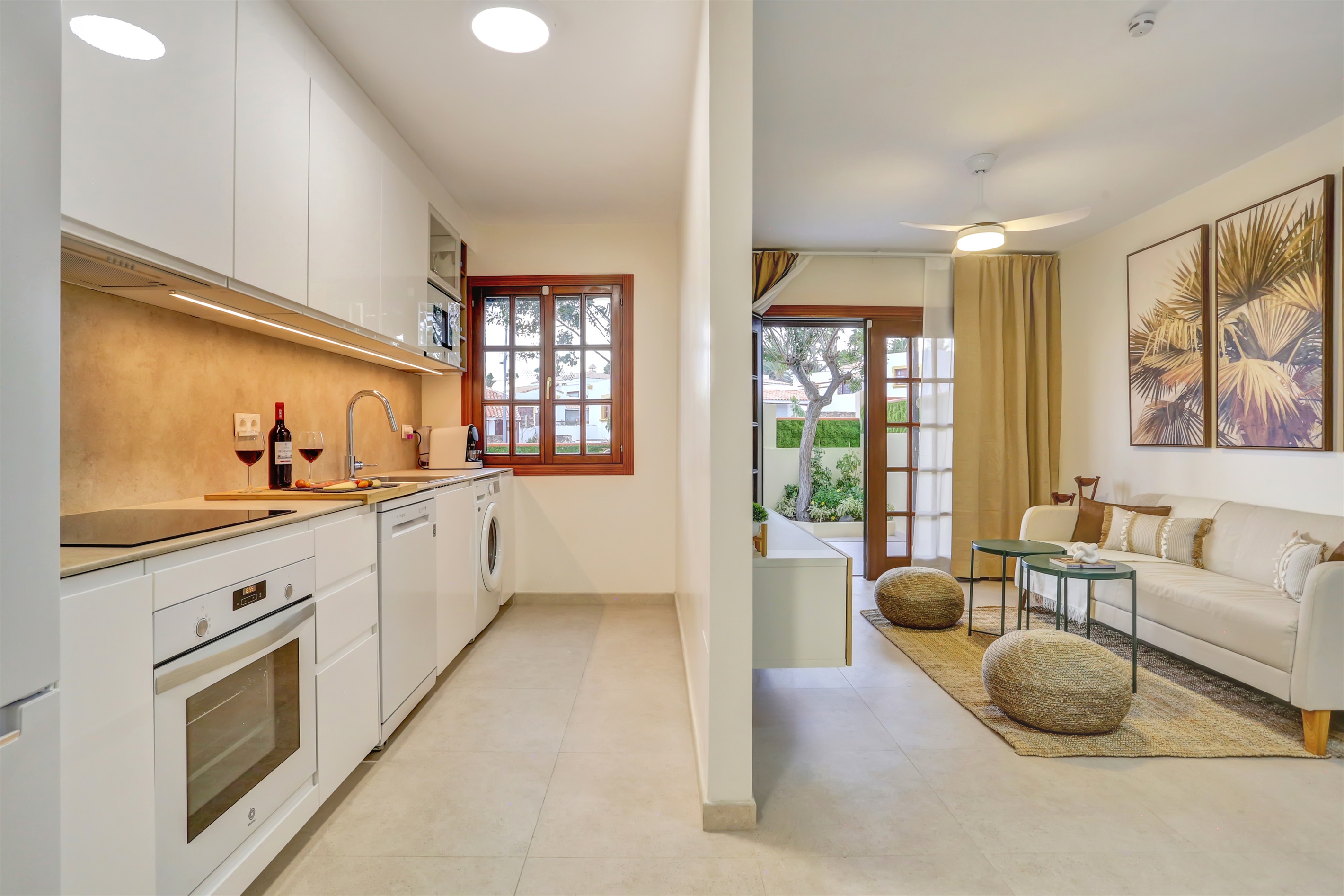 Modern open-plan space integrating the kitchen and living room with direct access to the garden, creating a bright, spacious, and welcoming atmosphere.