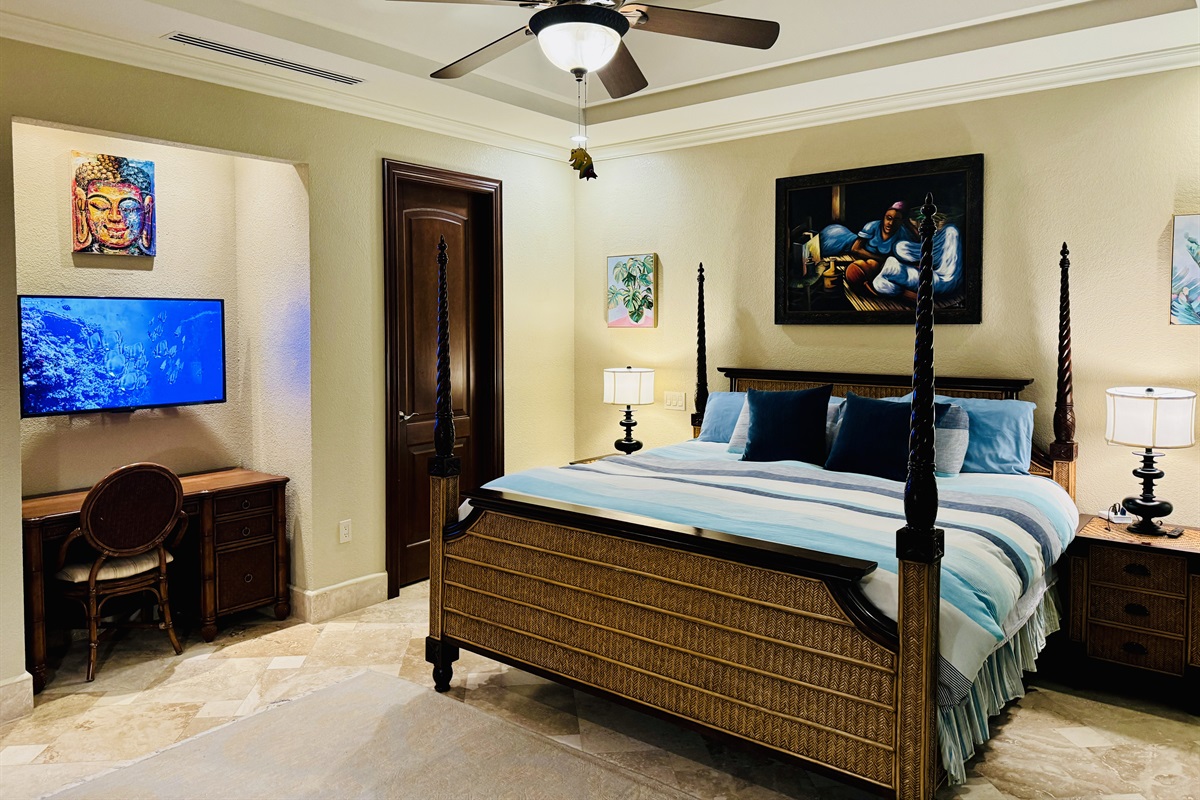 Primary bedroom with king bed, walk in closet, private workspace with smart tv