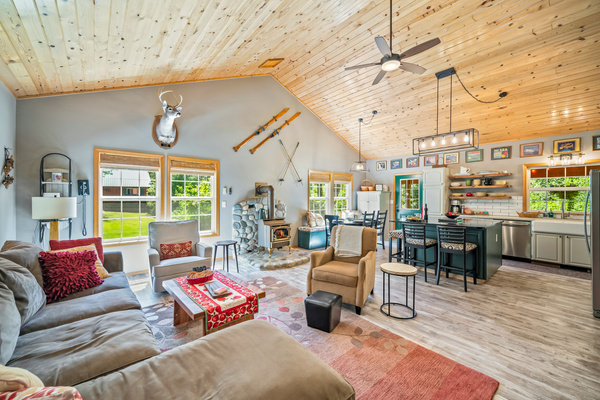 Open living area with large sectional, gas fireplace, dining room and kitchen with large island.