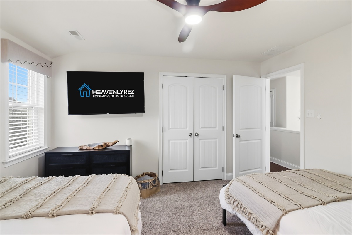 Comfortable twin bedroom with TV and spacious closet
